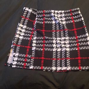 Plaid Red, White, and Black Mini skirt with mini slit at the bottom.